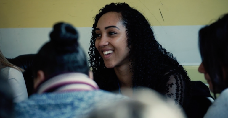 Smiling female student sitting amongst others